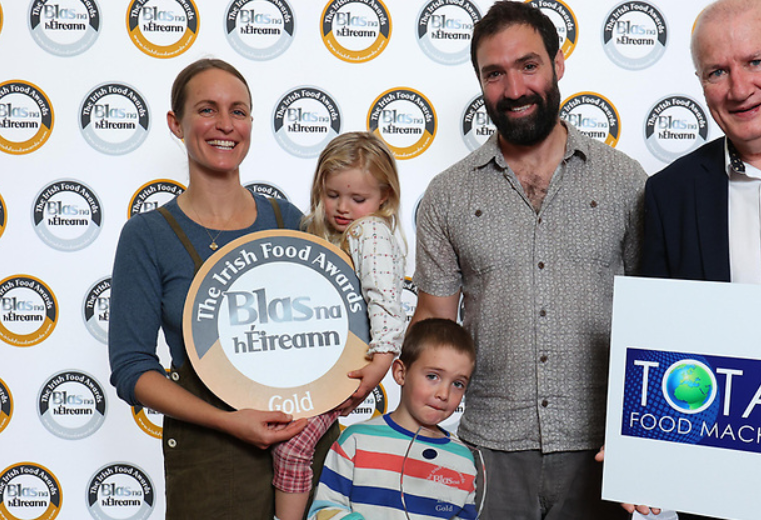 Family holding awards in front of a branded backdrop